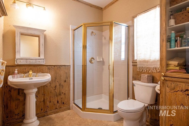 8344 Partridge Dr, Nampa, ID 83686 - bathroom with a wainscoted wall, toilet, a shower stall, crown molding, and wooden walls