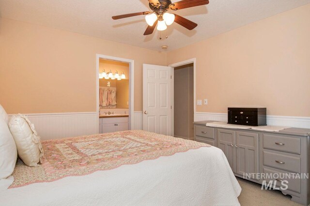 8344 Partridge Dr, Nampa, ID 83686 - bedroom with light colored carpet, ensuite bath, a ceiling fan, and a wainscoted wall