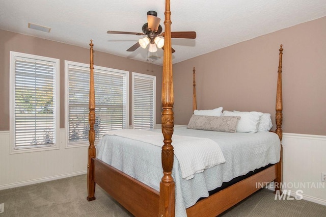 8344 Partridge Dr, Nampa, ID 83686 - carpeted bedroom featuring wainscoting, baseboards, visible vents, and ceiling fan