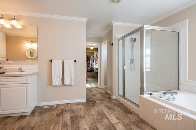8344 Partridge Dr, Nampa, ID 83686 - full bath with wood finished floors, a stall shower, a walk in closet, vanity, and ornamental molding