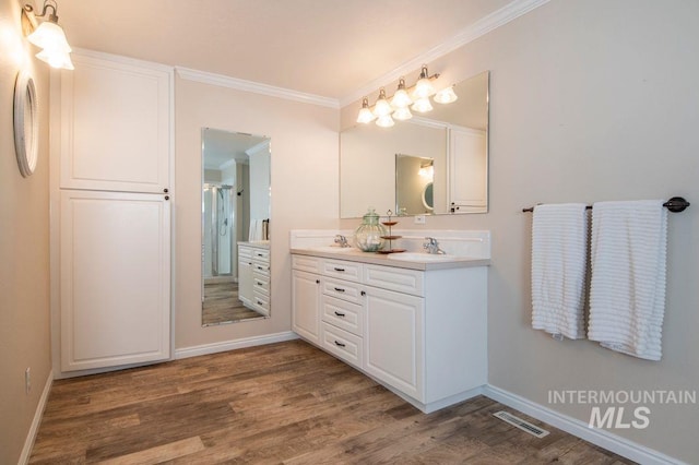 8344 Partridge Dr, Nampa, ID 83686 - bathroom with double vanity, a stall shower, visible vents, wood finished floors, and crown molding