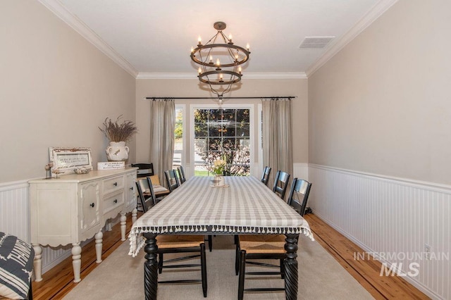 8344 Partridge Dr, Nampa, ID 83686 - dining area featuring light wood finished floors, visible vents, a chandelier, and crown molding