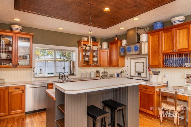 8344 Partridge Dr, Nampa, ID 83686 - kitchen featuring a center island, a breakfast bar, dishwasher, light wood finished floors, and light countertops