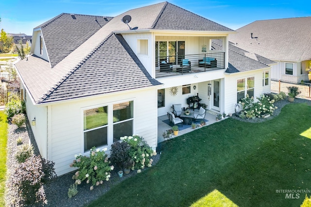 back of property with a balcony, a yard, and a patio