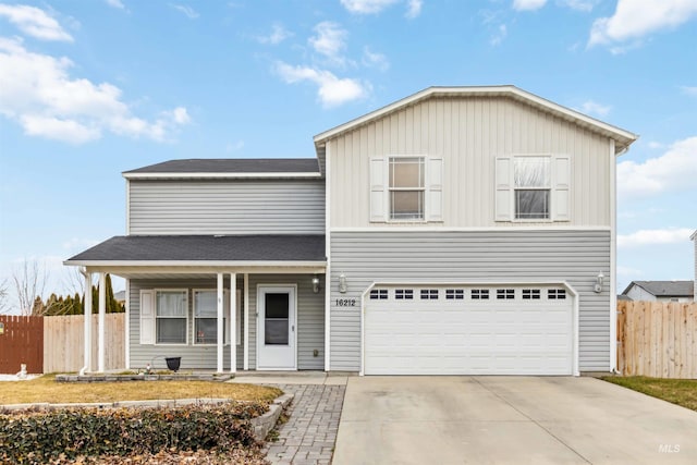 traditional home featuring a garage, driveway, covered porch, and fence