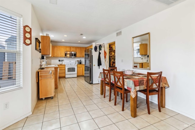 kitchen featuring visible vents, appliances with stainless steel finishes, a sink, and light tile patterned flooring