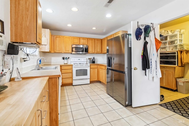 kitchen featuring light tile patterned floors, recessed lighting, stainless steel appliances, a sink, and visible vents