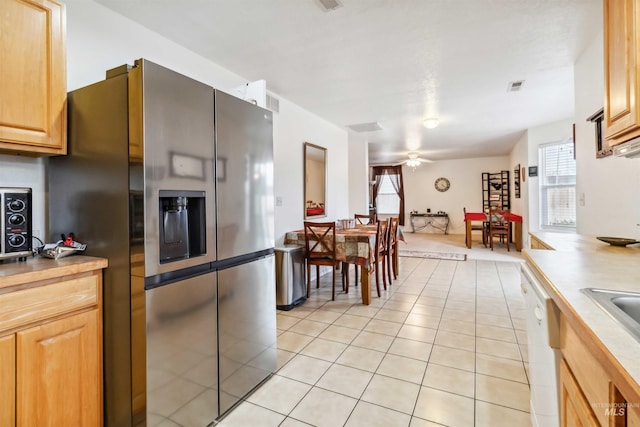 kitchen featuring light tile patterned floors, white dishwasher, visible vents, a ceiling fan, and stainless steel refrigerator with ice dispenser