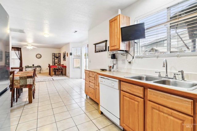 kitchen with light tile patterned floors, a ceiling fan, dishwasher, light countertops, and a sink