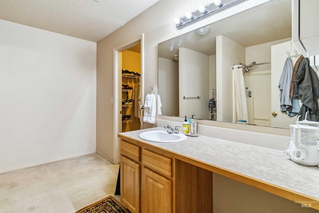 bathroom featuring a spacious closet, curtained shower, vanity, and baseboards