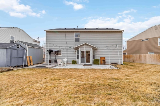 rear view of property featuring a lawn, a patio, fence, an outdoor structure, and a shed