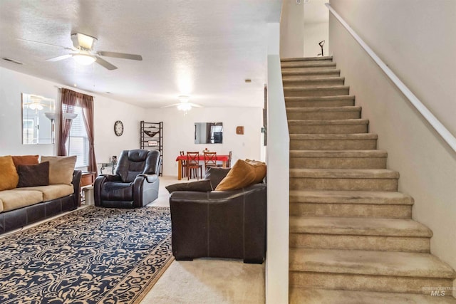 staircase featuring a ceiling fan, visible vents, and carpet flooring