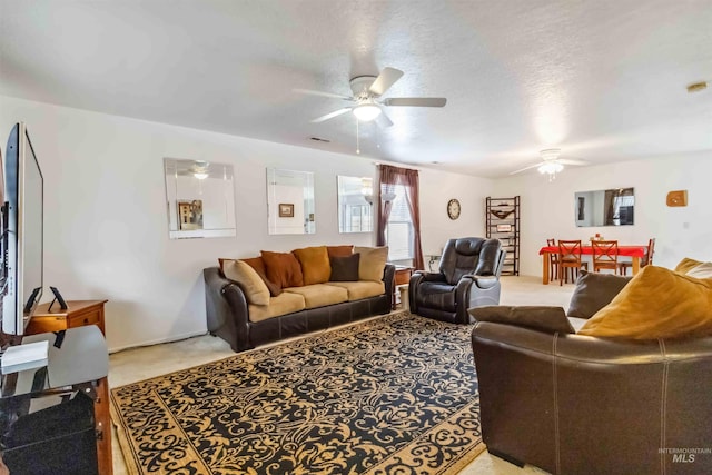 carpeted living room with ceiling fan and a textured ceiling