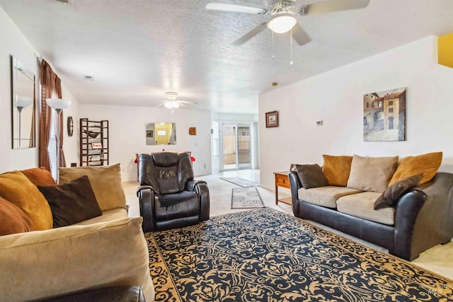 living area with light colored carpet, ceiling fan, and a textured ceiling