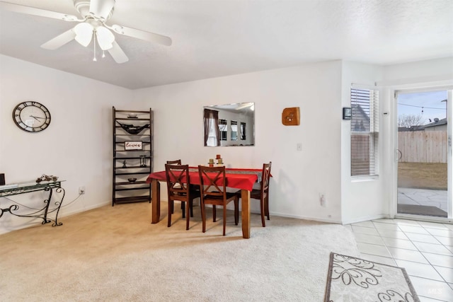 dining area with light carpet, ceiling fan, baseboards, and light tile patterned flooring