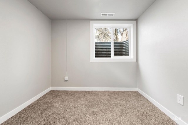 unfurnished room with carpet, visible vents, and baseboards