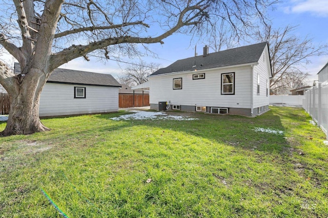 back of house featuring cooling unit, a fenced backyard, a yard, and a chimney