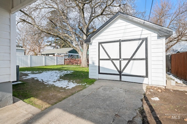 view of shed featuring concrete driveway and a fenced backyard