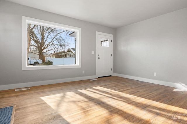 entrance foyer with visible vents, baseboards, and wood finished floors