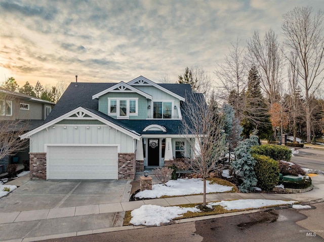 craftsman house with a garage, concrete driveway, brick siding, and board and batten siding