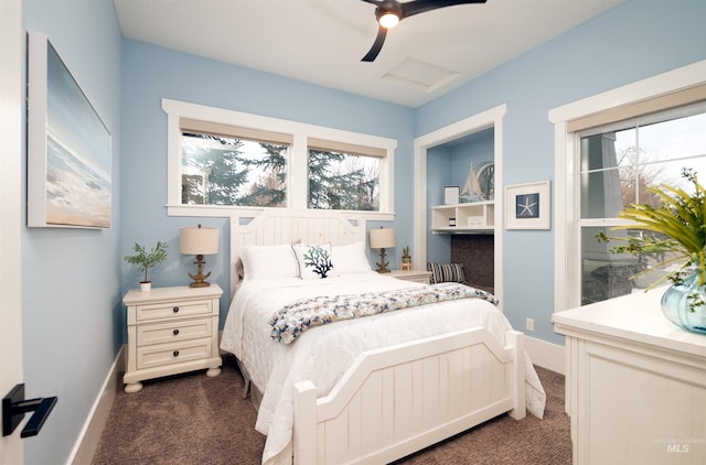 bedroom with a ceiling fan, attic access, dark carpet, and baseboards