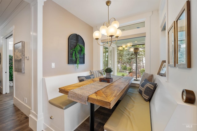 dining room with dark wood-type flooring, a notable chandelier, and baseboards