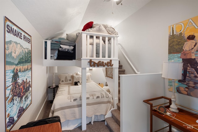 carpeted bedroom featuring lofted ceiling and a textured ceiling