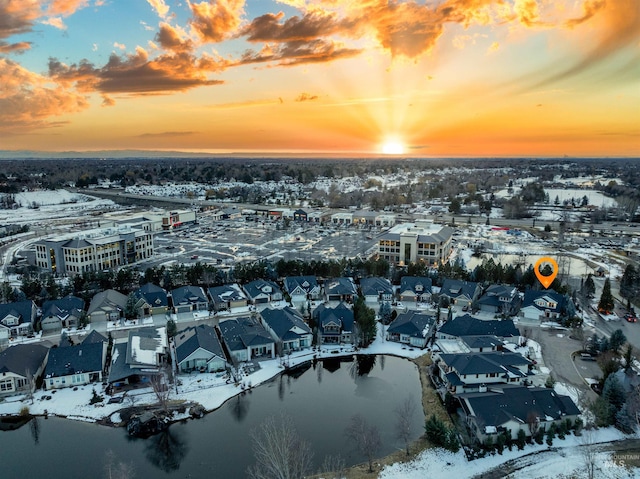 snowy aerial view featuring a residential view and a water view