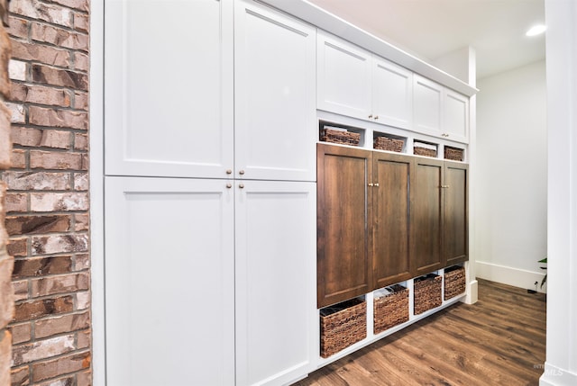 mudroom with brick wall, dark wood-type flooring, recessed lighting, and baseboards