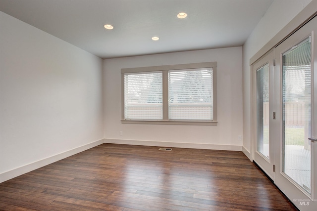 empty room featuring dark hardwood / wood-style flooring and a wealth of natural light