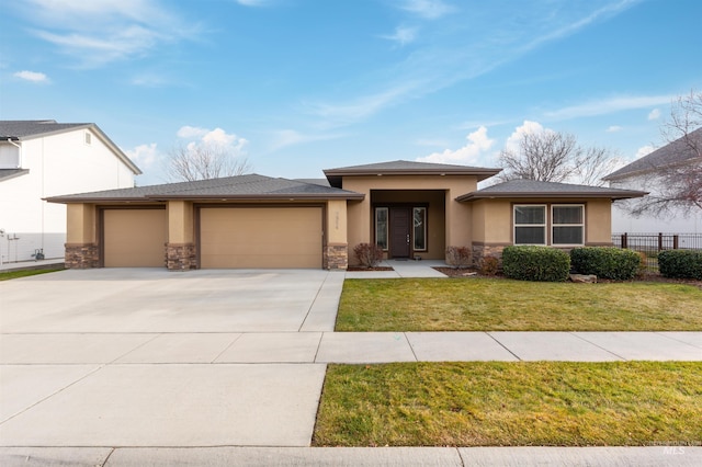 prairie-style home featuring a garage and a front yard