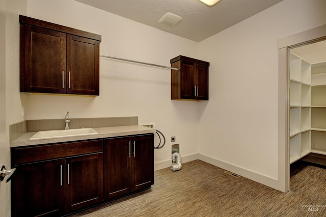 laundry area with cabinets, sink, washer hookup, a textured ceiling, and hookup for an electric dryer