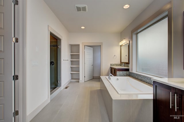 bathroom featuring vanity, a healthy amount of sunlight, and shower with separate bathtub