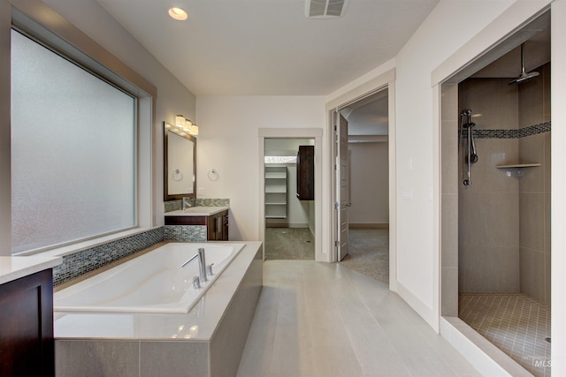 bathroom featuring tile patterned flooring, vanity, and shower with separate bathtub