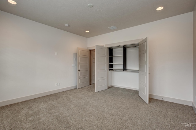 unfurnished bedroom featuring a closet and light colored carpet