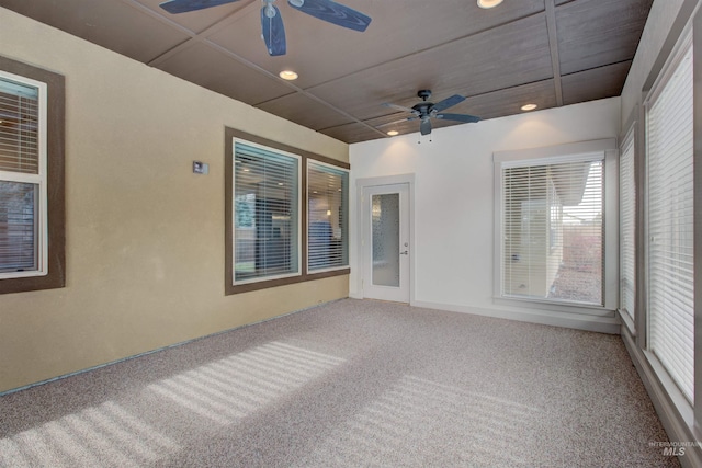 carpeted empty room with ceiling fan and a healthy amount of sunlight