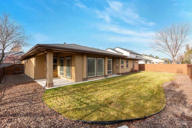 back of house featuring a lawn and a patio