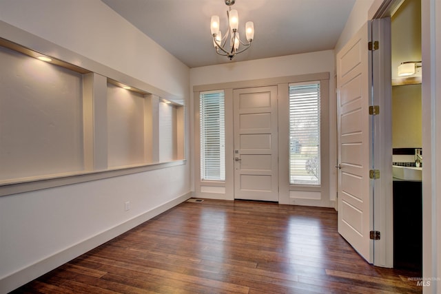 entryway featuring dark hardwood / wood-style floors and an inviting chandelier