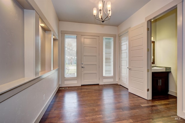 entrance foyer featuring a notable chandelier and dark wood-type flooring