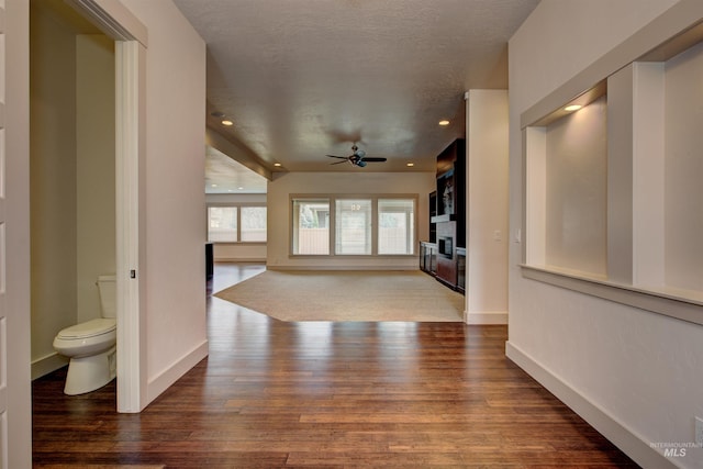 hall with hardwood / wood-style floors and a textured ceiling