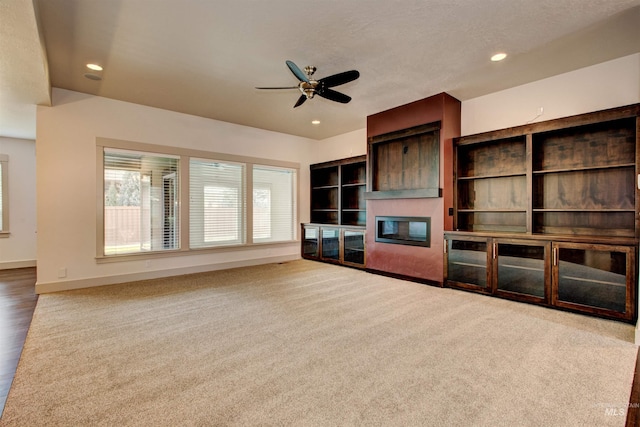 unfurnished living room featuring ceiling fan and carpet floors