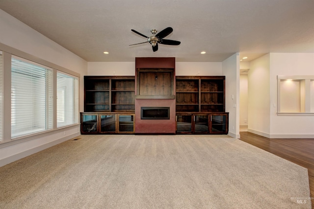 unfurnished living room featuring ceiling fan and hardwood / wood-style flooring