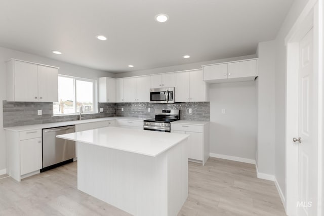 2351 W Opalite Dr, Kuna, ID 83634 - kitchen with appliances with stainless steel finishes, tasteful backsplash, light wood-style flooring, white cabinets, and recessed lighting