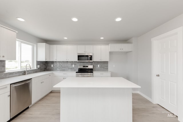 2351 W Opalite Dr, Kuna, ID 83634 - kitchen with stainless steel appliances, backsplash, a center island, white cabinets, and light countertops