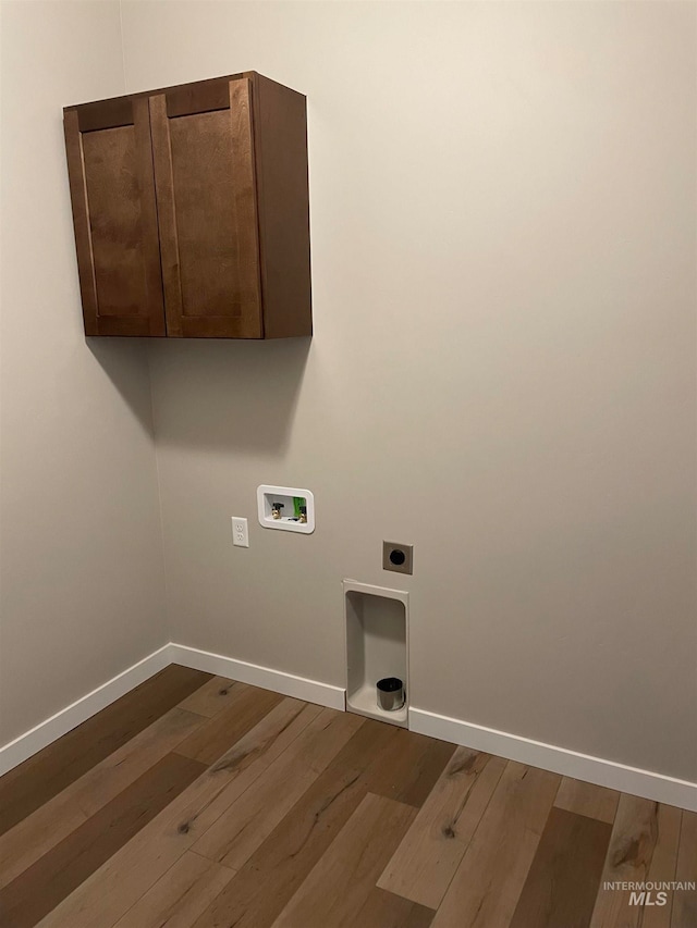 clothes washing area with washer hookup, cabinets, hardwood / wood-style floors, and electric dryer hookup