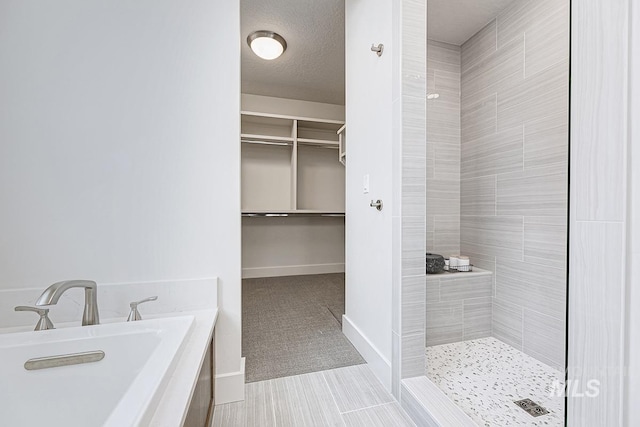 7029 S Tindaris Ave, Meridian, ID 83642 - bathroom featuring a tile shower, a garden tub, and a spacious closet
