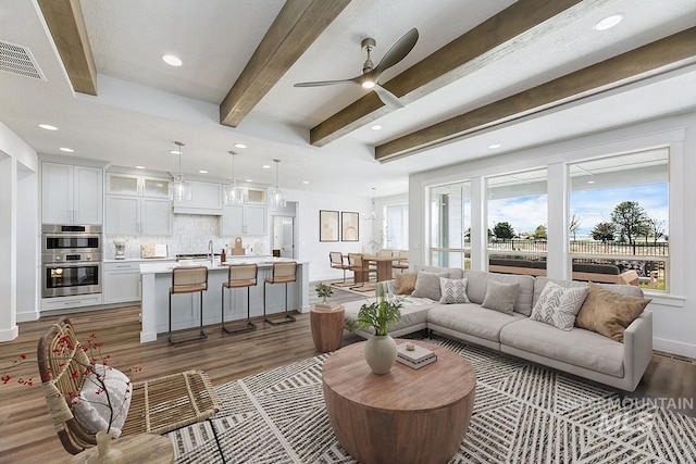 7029 S Tindaris Ave, Meridian, ID 83642 - living area with wood finished floors, beamed ceiling, recessed lighting, and ceiling fan