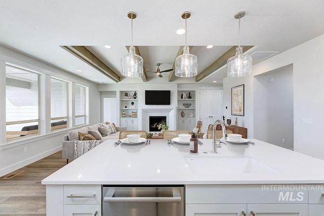 7029 S Tindaris Ave, Meridian, ID 83642 - kitchen featuring open floor plan, stainless steel dishwasher, light countertops, white cabinets, and wood finished floors