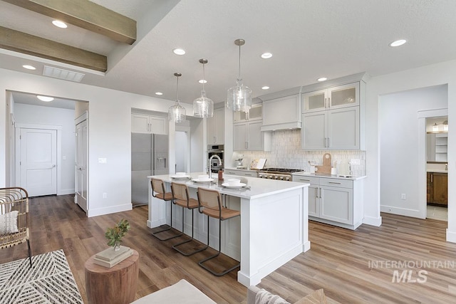 7029 S Tindaris Ave, Meridian, ID 83642 - kitchen featuring fridge with ice dispenser, light countertops, tasteful backsplash, a kitchen island with sink, and recessed lighting