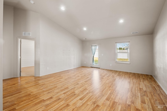 unfurnished room with vaulted ceiling, light wood finished floors, visible vents, and recessed lighting